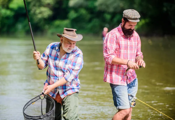 Pazzo Mans Hobby. Tempo di pesca a mosca. hobby. due pescatori felici con canna da pesca e rete. turismo di caccia. padre e figlio pesca. Pesca d'altura. amicizia. Campeggio sulla riva del lago — Foto Stock