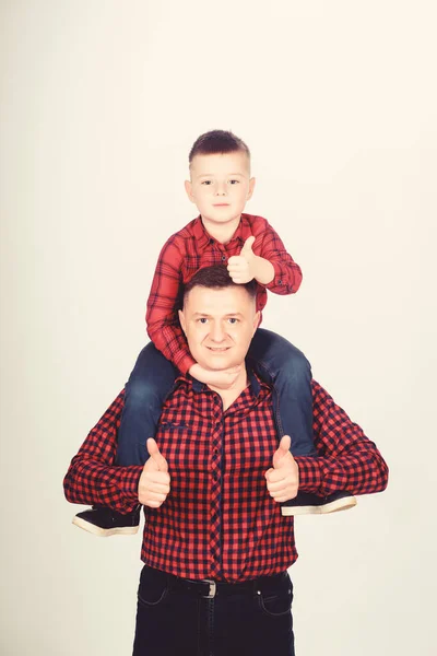 Father little son red shirts family look outfit. Best friends forever. Dad piggybacking adorable child. Having fun. Happiness being father of boy. Fathers day. Father example of noble human