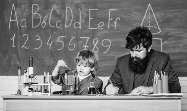 Formula. experiments in organic chemistry laboratory. small boy with teacher man. Wisdom. Back to school. son and father at school. biotechnology research concept. Education engages a man.