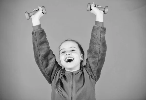 Sport framgång. Workout av liten flicka hålla hantel. styrketräning för muscules. Barndoms aktivitet. Fitness diet för energi hälsa. Happy Child Sportsman med skivstång. känna framgång. framgång inom idrotten — Stockfoto