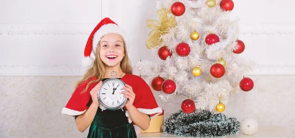 Nový rok countdown. Dívka dítě santa klobouk kostým s hodinami vzrušený šťastný obličej počítat čas do nového roku. Last minute do půlnoci. Last minute Silvestr plány, které jsou ve skutečnosti spousta zábavy — Stock fotografie