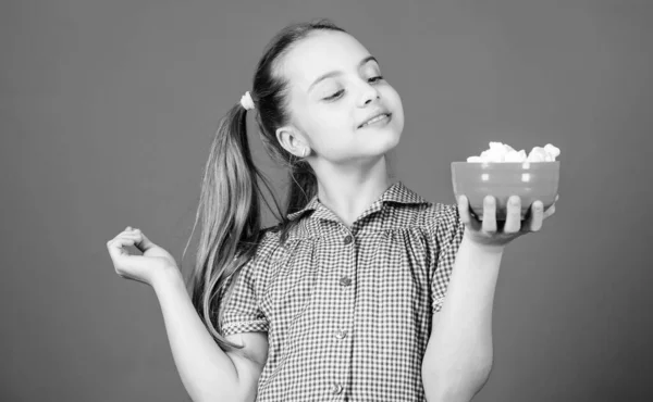 Calorie e dieta. Ragazza sorridente faccia tenere ciotola dolci marshmallow in mano sfondo blu. Ragazza con i capelli lunghi come mangiare dolci e dolcetti. Sweets l'unico vero amore. Dolce concetto di dente — Foto Stock