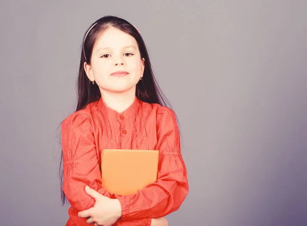 Language and literature textbook for self study. Cute little child holding book in English literature. Adorable small girl enjoy reading literature book. Educational books and literature, copy space