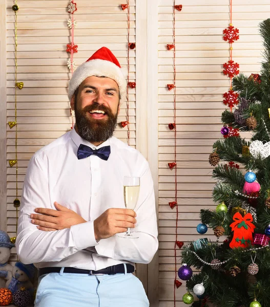 Mannen med skägg håller champagneglas. Jultomten i hatt — Stockfoto