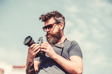 İçerik oluşturucu. Adam sakallı hipster fotoğrafçısı. Adam fotoğraf çekiyor. Eski ama yine de iyi. Manuel ayarlar. Fotoğrafçı vintage kamera tutun. Modern blogcu. Sakallı ve bıyıklı fotoğrafçı
