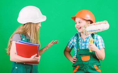 silindir aracı. Tablet ve rulo ile kask küçük çocuklar. İşçi bayramı. 1 mayıs. Foreman müfettişi. Onarım. küçük kızlar rulo ile atölyede birlikte tamir. okul projesi. evde rulo kullanma
