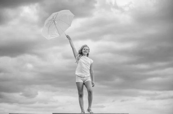 トレンディな美しさ。学校の時間。秋の季節。雨の天気予報。秋の子供のファッション。曇り空の子供。雨の保護。傘を持つ幸せな小さな女の子。どんな天候でもポジティブな気分 — ストック写真