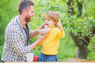 Aile ev yapımı yemeklerin tadını çıkarır. Baba oğul yemek yer ve eğlenir. Küçük çocuk ve baba yemek yiyor. Çocuklar ve yetişkinler için beslenme. Sağlıklı beslenme kavramı. Bebeği besliyor. Çocuklar için menü. Beslenme alışkanlıkları