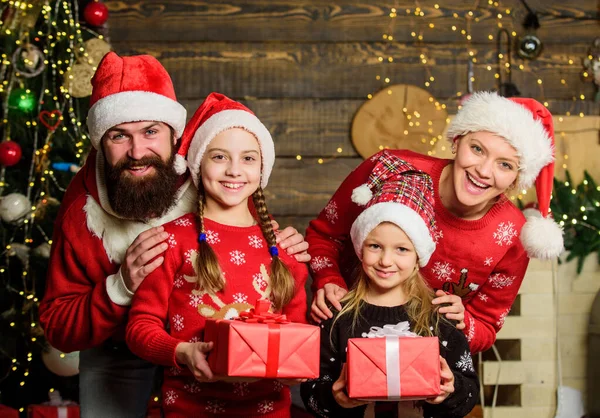 A família feliz celebra o Ano Novo e o Natal. Pai Natal na árvore decorada. mãe alegre ama crianças. meninas pequenas irmãs com pais. presentes do Pai Natal. Momentos de escolher o melhor presente. — Fotografia de Stock