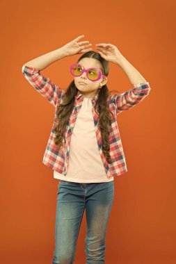 Gözlüklerim de benim kadar eşsiz. Turuncu arka planda süslü gözlükler takan sevimli küçük kız. Moda gözlüğü aksesuar ile sevimli küçük çocuk. Onun tarzı için mükemmel trendy gözlük seçimi