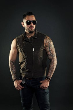 Pazı ve triceps dövmeli adam. Tıraşsız yüzündeki sakallı dövme modeli. Güçlü silah dövme sakallı adam. Moda maço trendy güneş gözlüğü. Moda stil ve eğilim