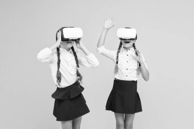 Yeni deneyimlerin tadını çıkar. Mutlu çocuklar modern teknolojiyi kullanır. Gelecekteki eğitim. Okula dönüyorum. Dijital gelecek ve yenilik. Sanal gerçeklik. VR kulaklıklı küçük kızlar. Çocuklar kablosuz VR gözlük takıyor