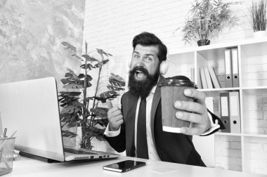 Eğlenmene bak. Şarkı söyleme hobisi. Erkek ofis çalışanı müzik kulaklığı dinliyor. Stres direnci konsepti. Müdür favori müzik ve fincan kahveyle rahatlıyor. Ofiste sıradan bir sabah. Motivasyon müziği