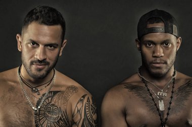 Siyah arka plan üzerine izole moda modelleri. Acımasız adam dövmeli organları ile. Sporcular kaslar, egzersiz kavramı ile. Geriye doğru beyzbol şapkası giyen Afrika adam. Geniş sırıtma ile beyaz sakallı adam