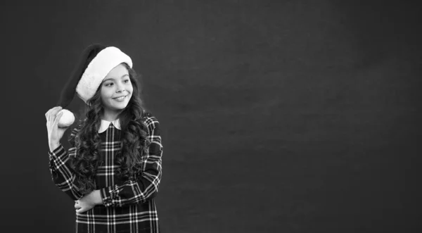 Boas férias de inverno. Menina pequena. Presente para o Natal. Infância. Compras de Natal. Criança no chapéu vermelho do Pai Natal. Festa de Ano Novo. Miúdo do Pai Natal. Momento mágico. espaço de cópia . — Fotografia de Stock