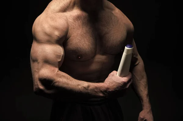 Butelka szamponu w silną ręką człowieka. Potrzebuję szampon i ciała. człowiek. — Zdjęcie stockowe