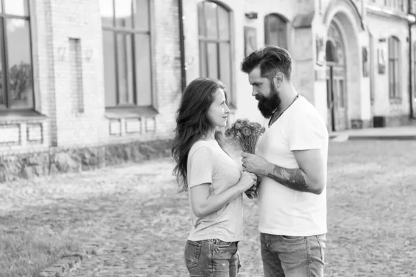 Couple meeting for date. Bouquet gift. Man giving flower bouquet. Romantic date. Guy prepared surprise bouquet for girlfriend. True feelings. Pick up girl for date. Bearded hipster fall in love — Stock Photo, Image