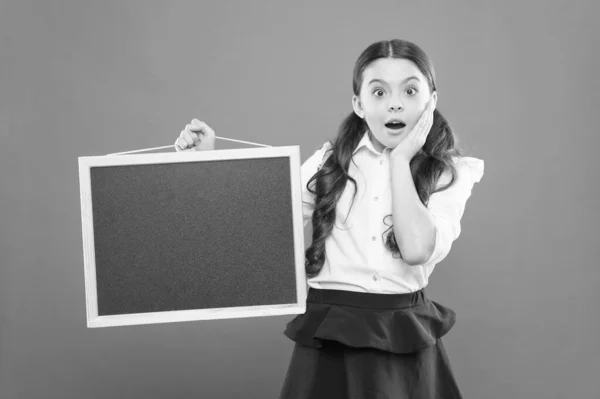 O jee. verraste leerling in school uniform. Kopieer ruimte. commerciële marketing conept. Business School advertentie. nieuw winkel idee. verkoop op de school markt. Signage. verrast schoolmeisje met Blackboard — Stockfoto