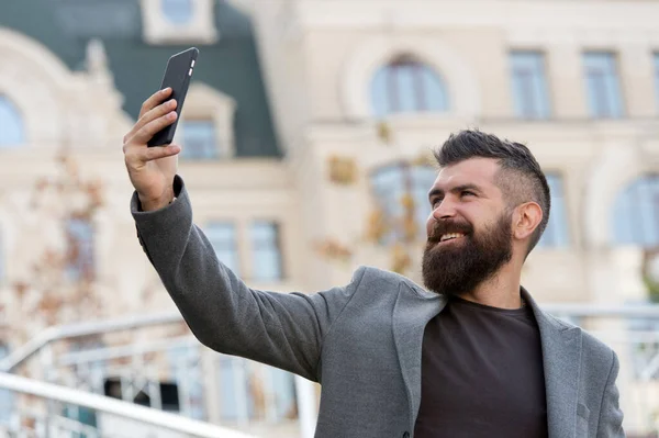 Ahoj. Muž s úsměvem fotit selfie smartphone městské pozadí. Probíhá vysílání online videohovoru. Mobilní internet. Mobilní telefon Hipster. Obsah blogu. Osobní blog. Moderní život. Mobilní internet — Stock fotografie