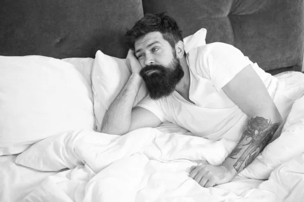 What a long night. Sleep disorders concept. Man bearded hipster having problems with sleep. Guy lying in bed try to relax and fall asleep. Relaxation techniques. Violations of sleep and wakefulness