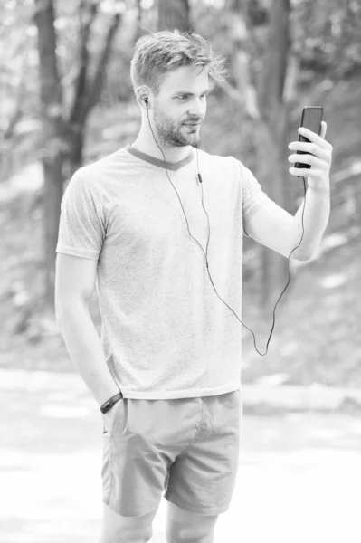 피트니스 목표를 달성하기 위해 설계된 전화. 야외에서 휴대 전화에서 화상 통화를하는 스포츠맨. 자신의 휴대 전화에서 라우드 스피커 모드를 사용하여 운동 남자. 어디서나 연결해 주는 전화 — 스톡 사진