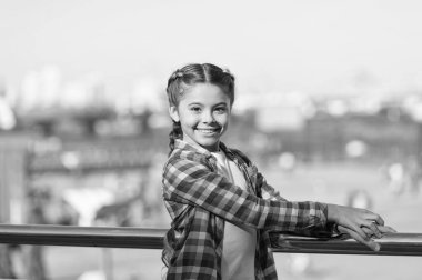 Gerçekten çok tatlı. Esmer saçlı küçük çocuk moda tarzında gülümsüyor. Yaz gününde sevimli bir çocuk. Şehir sokağındaki mutlu kız çocuğu. Çekici gülüşü ve güzelliği olan küçük çocuk.