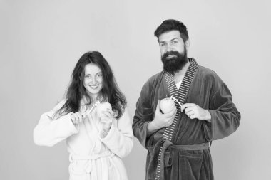 Dişleri sağlıklı tutun. Sağlıklı alışkanlıklar. Her sabah dişleri fırçala. Ağız hijyeni. Çift bornozdiş fırçası ve elma tutun. Kişisel hijyen. Aşkta diş temizliği ne kadar aşık. Tazelik ve temizlik