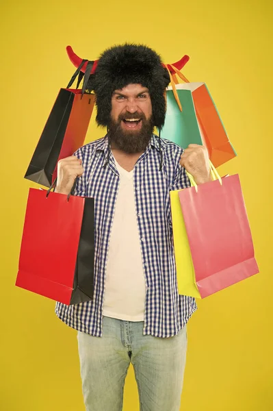 Una compra maravillosa. Hombre barbudo sonriendo con compra personal. Feliz hipster en sombrero de cuernos de toro sosteniendo su compra en bolsas de papel. Compra de moda compra — Foto de Stock