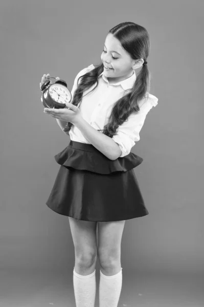 Hora del colegio. Educación infantil. Día del conocimiento. Es hora de ir a la escuela. Chica feliz mantenga el despertador contando para la hora del almuerzo. horario de rutina diaria. colegiala y despertador retro. Regreso a la escuela — Foto de Stock