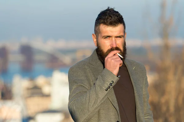 Smoking devices concept. Bearded hipster smoking outdoors. Device hide conceal smell of smoke. Handsome man smoke flying out of mouth. Cigarette tobacco harmful health influence. Smoking aesthetics — Stock Photo, Image