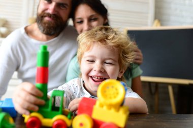 Ebeveynler oğlunun renkli tuğlalarla oynamasını seyrediyor..