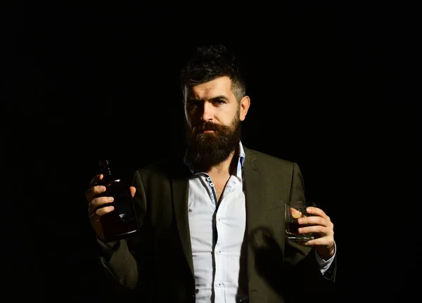 Άντρας που κρατάει ένα ποτήρι ουίσκι ή μπέρμπον και μπουκάλι — Φωτογραφία Αρχείου