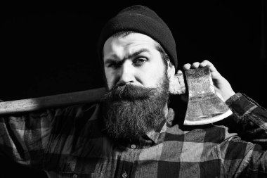 Kaşları çatık adam siyah arka plana balta koyuyor