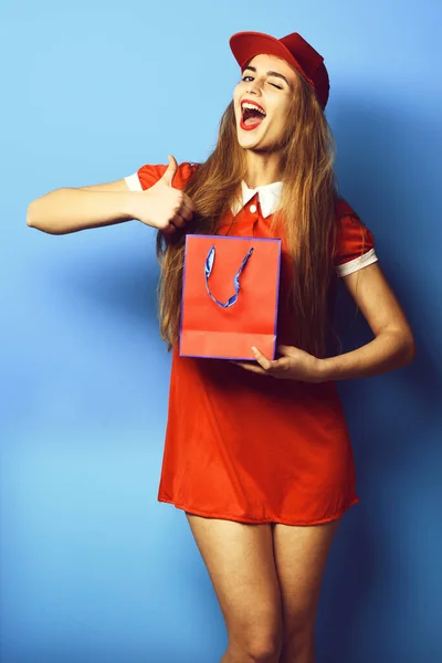 Fille colorée souriante avec chapeau sur fond bleu studio — Photo