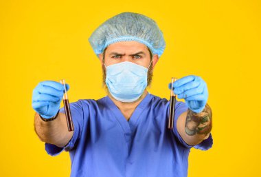 Bir çeşit virüs. Coronavirus konsepti. Virüsün mutasyona uğramasını bekle. İnsandan insana iletim. Sürekli yeni virüsler tespit ediliyor. Virüs salgınının başlangıcı. Erkek doktor üniforması sarı arka plan