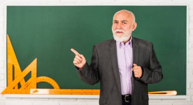 Bak ve öğren. Okula dönüyorum. Matematik aletleri. Sınıfta trigonometri dersi. Bilgileri buraya getir. Son sınıf öğretmeni matematik aletleri kullanır. Sakallı okutman tahtada geometriyi açıklıyor..