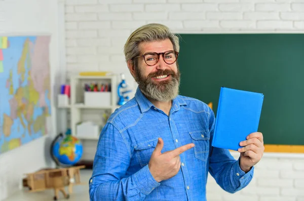 한 번해 보 세요. 언어를 배우는 것입니다. 안경을 쓴 엄격 한 선생님. 교사는 지식을 조사 한다. 검사받을 준비 됐어요. 교실에서 남자 교사. 노트나 책을 사용 한다. 다시 학교로 — 스톡 사진
