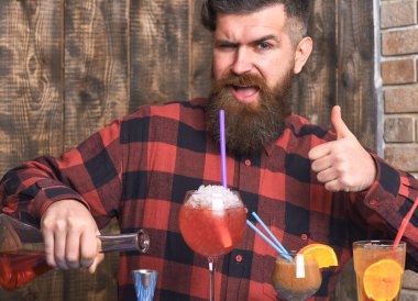 Hipster içkiyi sever ve onaylar. Sakallı barmen.