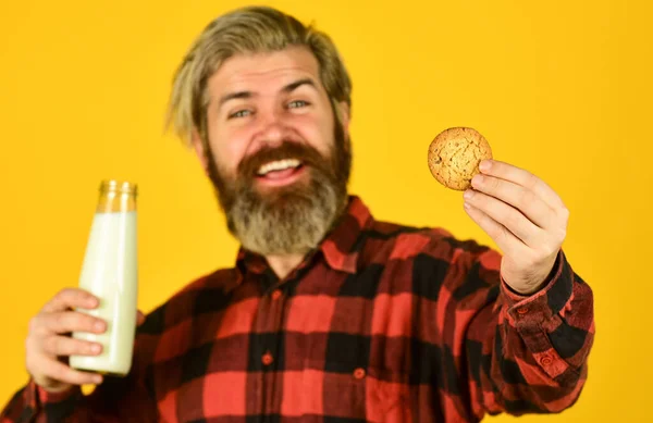 Milk and sweet cookie. Delicious as in childhood. Mature bearded man drink milk with cookie. Breakfast tradition. Happy hipster eat cookie dessert. Yummy combination. Recipe homemade cookies