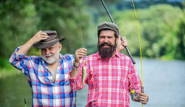 La familia es lo mejor. pasatiempo y actividad deportiva. Cebo para truchas. fin de semana de verano. hombres maduros pescador. padre e hijo pescando. dos pescador feliz con cañas de pescar. amistad masculina. vinculación familiar —  Fotos de Stock