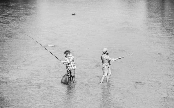 play game. recreation and leisure outdoor. Big game fishing. male friendship. two happy fisherman with fishing rod and net. hobby and sport activity. Trout bait. father and son fishing. adventures