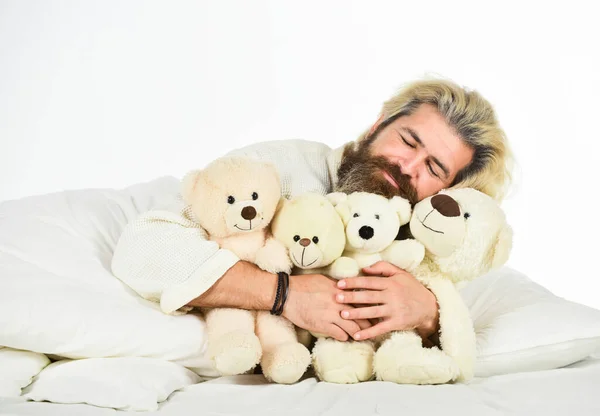 Happy Valentines day. Sick man with flu sleeping in the bed. sleeping at home in bed with his toy. man sleeping in embrace with white teddy bear. Handsome hipster hold lovely bear toy