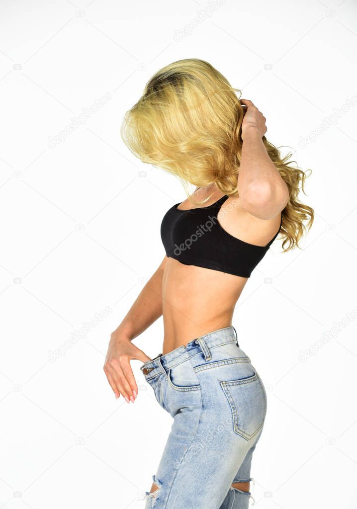 Dieting and fitness. Impressive result. Girl shows big size of her pants and slim belly. Slim fit woman denim pants. Girl on diet lost weight white background. Loss weight concept. Healthy lifestyle