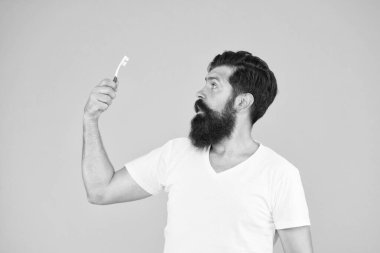 Dişlerini fırçala. Sakallı adam, diş fırçasına bak. Günlük ağız temizliği. Diş sağlığı alışkanlıkları. Düzgün ve düzenli fırçala. Diş fırçalama ve temizlik. Temiz dişler. Fırçalarken acele etme.