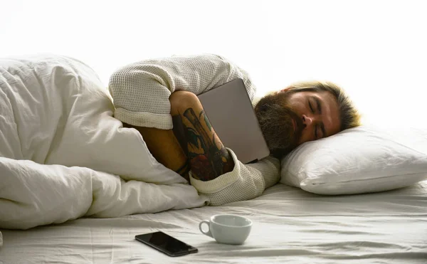 ガジェットとは不可分だ。健康な睡眠。ソーシャルネットワークの依存関係。青い光効果。眠い顔の男はノートパソコンの枕の上にある。深い睡眠の概念。髭や髭を生やした男が — ストック写真