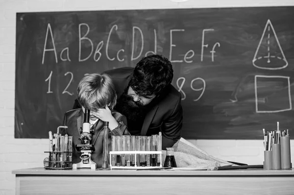 Ajuda e apoio. Menino pequeno com professor. Frasco na mão do cientista com tubos de ensaio. Sabedoria. De volta à escola. Filho e pai na escola. Química e biologia física — Fotografia de Stock