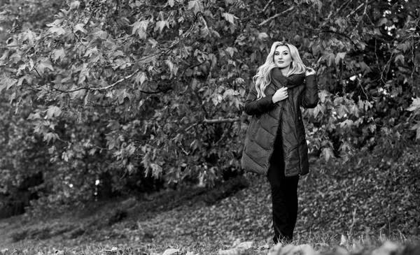 Flicka fashionabla blonda promenad i höstparken. Kvinnan bär varm jacka. Jackor som alla borde ha. Bästa puffertkappa att köpa. Hur man plockar puffertkavaj. Ett renodlat modekoncept. Professionell stylist råd — Stockfoto