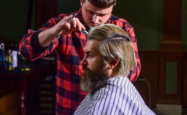 Un cliente hipster che si taglia i capelli. Forbici da barbiere. Gestisci le tue aspettative. Taglia i capelli. Barbiere fare acconciatura per barbuto uomo barbiere sfondo negozio. Ragazzo con lunghi capelli biondi tinti da vicino vista posteriore — Foto Stock