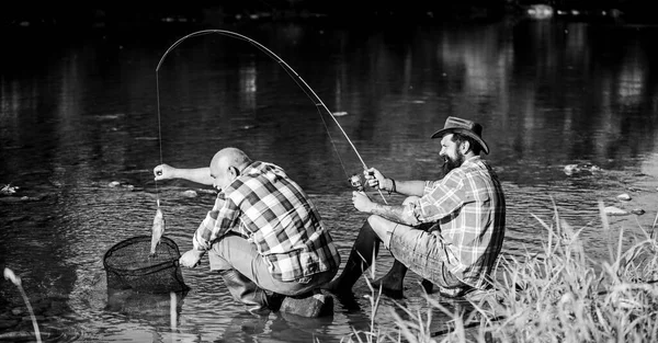 Fekete piaci kaviár. Orvvadászok horgásznak. Csapda a halaknak. A férfiak a folyóparton ülnek horgászfelszereléssel. Illegális kaviárvadászat. Tojásokat von ki a folyóba fogott tokhalból. Az orvvadászat és a halászati engedély — Stock Fotó