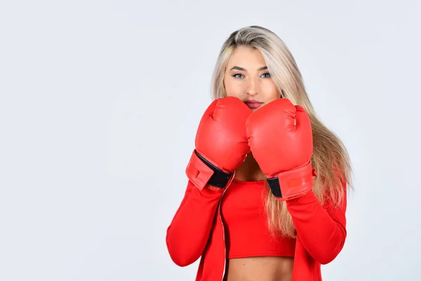 confident young sportswoman posing in boxing gloves. beautiful woman with red boxing gloves. young sports woman in tracksuit and boxing gloves. blond boxer woman. kick off